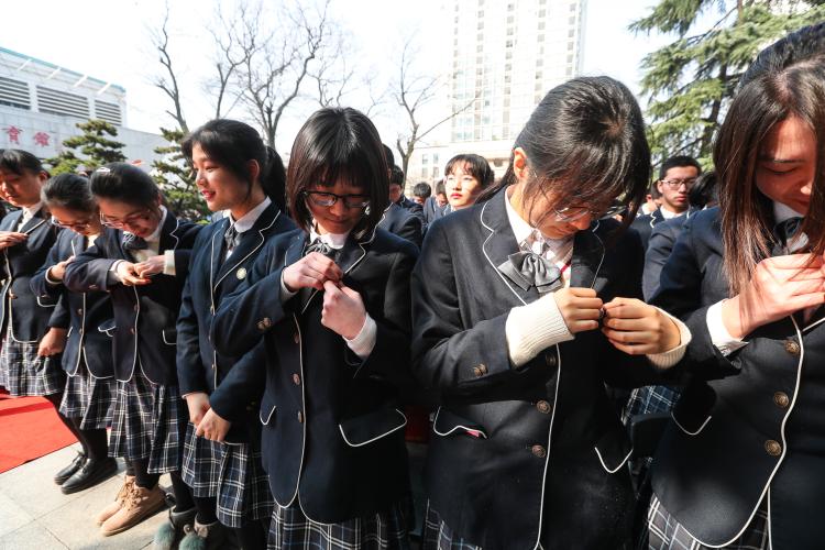 在学弟学妹们的祝福声中，全体高三学生佩戴成人徽章